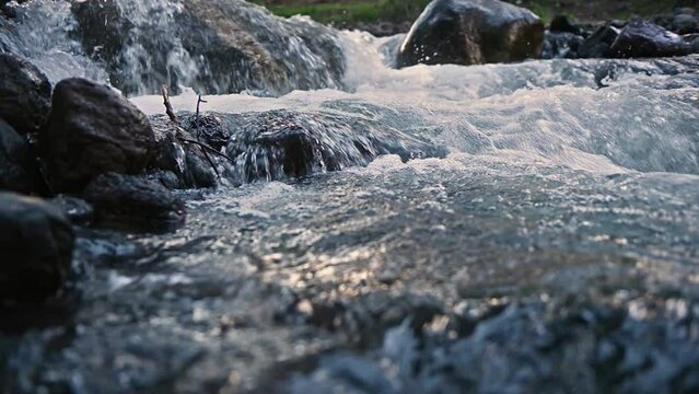 Slow motion of Norwegian mountain river , stream flowing through rocks. Close up of river stones with flowing water, clean water flowing in a mountain river at the Norway