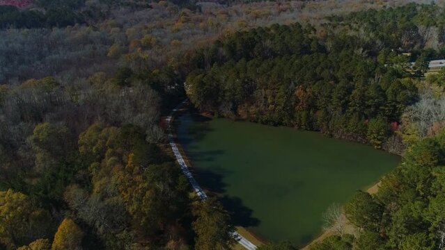 Aerial drone circle left to right view green triangle lake with oak trees riverdale ga.