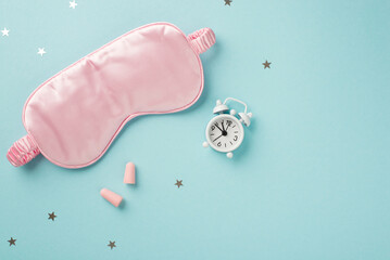 Top view photo of the big silk pink sleep mask little white clock with two pink earplugs and a...