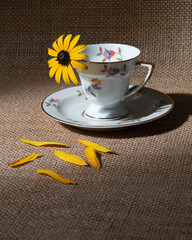 Yellow daisies and a cup of coffee on burlap