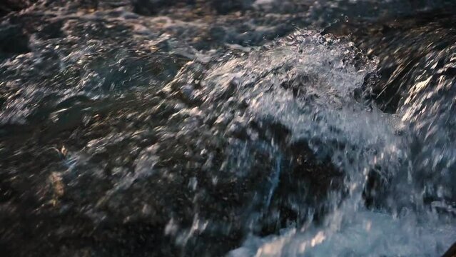 Slow motion of Norwegian mountain river , stream flowing through rocks. Close up of river stones with flowing water, clean water flowing in a mountain river at the Norway