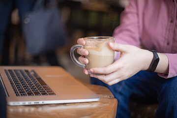 Young caucasian woman working via laptop at the cafeteria