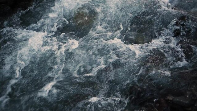 Slow motion of Norwegian mountain river , stream flowing through rocks. Close up of river stones with flowing water, clean water flowing in a mountain river at the Norway