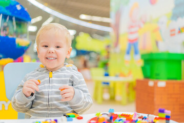 Fototapeta na wymiar little boy play colorful cubes puzzle at the table