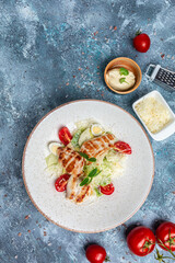 Delicious salad with grilled chicken, cheese, quail eggs and cherry tomatoes, with sauce. Delicious balanced food concept