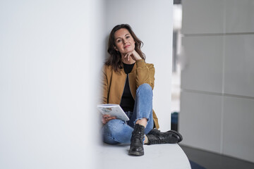 attractive brown hair student woman journaling thoughtful with pen in casual jeans outfit in a modern university lobby on a white background