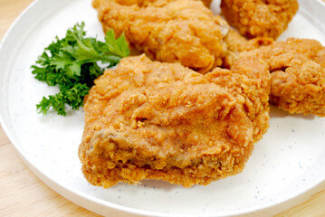 Close Up of a Southern Fried Chicken Thigh on a White Plate