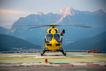 Rescue helicopter parked in a heliport in the Dolomites - obrazy, fototapety, plakaty