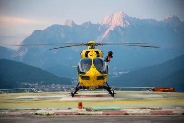 Tuinposter Rescue helicopter parked in a heliport in the Dolomites © Rebekka Fagnani