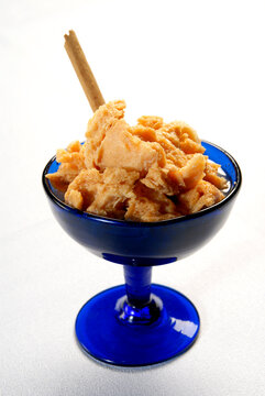 zamorano chongos dessert, traditional mexican sweet in a blue cup and cinnamon stick