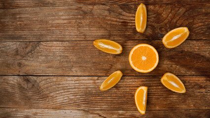 Citrus composition, orange in the shape of sun on the wooden background. Top view, space for text. The concept of summer, vacation and sunny weather.