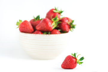 Fresh red strawberries with green leaves on white background.