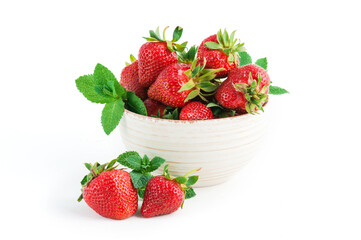 Fresh ripe delicious strawberries in ceramic bowl with leaves of green mint on white background.