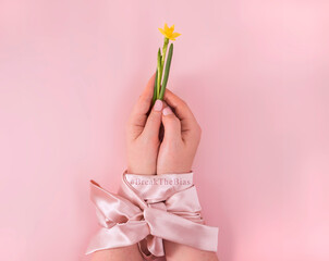 Break the bias women's day 2022 concept.  Symbol of woman's international day. bound hands holding a flower