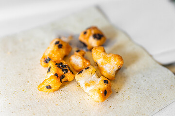 Traditional Japanese food on airplane flight with salty nori rice crackers on recyclable green tea napkin macro closeup showing texture of healthy baked snack