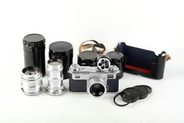 A set of lenses and accessories for old rangefinder film camera on white background.