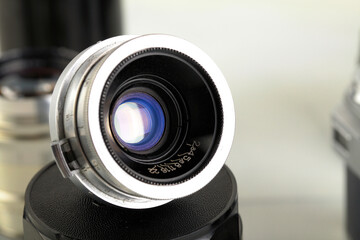Lens for an old rangefinder film camera on a white background.