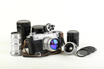 A set of lenses and accessories for old rangefinder film camera on white background.