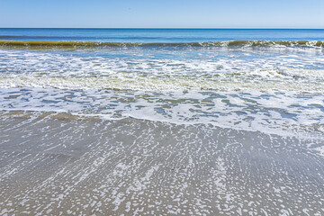 Myrtle Beach, USA shore coast at South Carolina with Atlantic ocean shore sunny day with view of blue sky horizon and sea foam waves