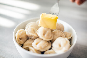 Closeup macro of traditional Russian dumplings pelmeni with meat filling stuffing in white bowl...