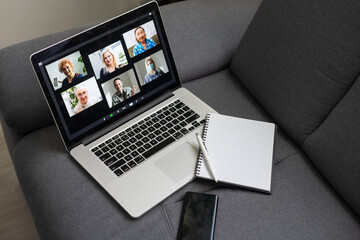 Laptop screen with multi-person conference, collage of group of multiracial people, webcam view, video chat. A lot of different headshots on computer monitor, virtual conference, video call.