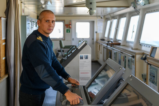 Deck officer on navigational bridge working with radar. Navigation. Commercial shipping. Passenger ship.