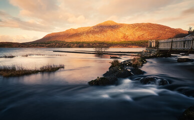 Beautiful cloudy sunrise landscape scenery with lake and mountains at Derryclare natural reserve in Connemara National park, county Galway, Ireland 