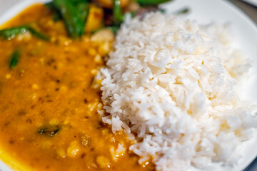 Macro closeup texture of orange red curry healthy coconut squash dal Indian yellow split peas sauce...