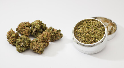 Close-up of medical marijuana buds, aluminum grinder, white background