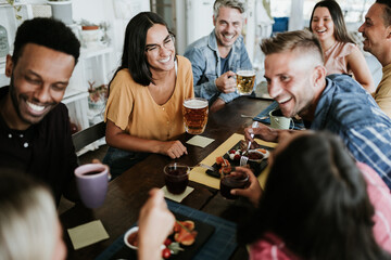 Happy group of young people having breakfast at bar bakery shop - United multiracial friends laughing together and having fun while drinking - Focus on asian woman