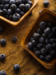 Blueberries in bowls on a wooden table. High angle view. Healthy food, vitamins, antioxidants, cooking, ingredients for pies, breakfast cereals, juices, fresh juices, jams.