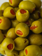 Macro shot. Green stuffed olives. Large group of objects. Healthy vegetarian food. Vitamins, antioxidants. Snacks, banquet, holiday, picnic. Restaurant, hotel, cafe, supermarket.