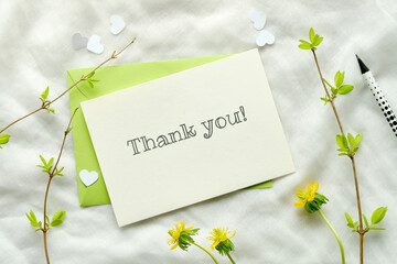 Thank you card. Spring background with green envelope and off white paper card. Yellow spring...