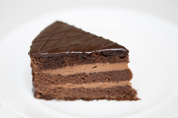 Piece of chocolate cake is on white background - 488259036