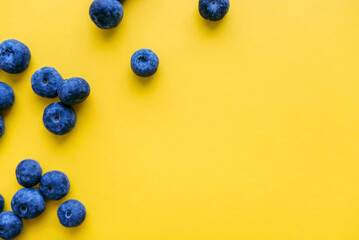 Blueberries on yellow background. Healthy food concept