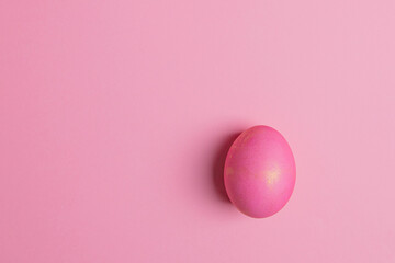 one easter pink egg on a pink background