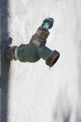 Exterior house dripping water faucet or tap in yard	