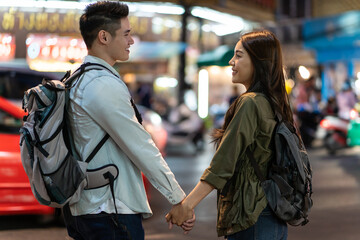 Asian active young couple travel in city for honeymoon trip at night. 