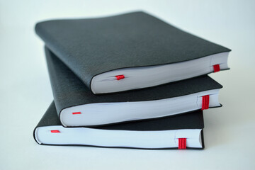 A stack of black diaries. Three notebooks. Close-up.