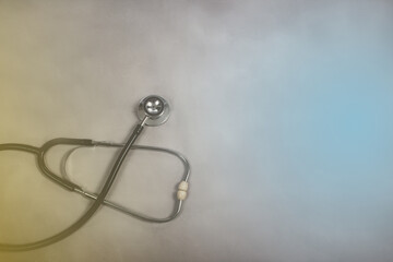 Obraz na płótnie Canvas Stethoscope on gray background with blue light, health and medical concept.