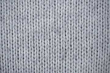 Gray texture from wool knitted material. Knitted pattern, background.