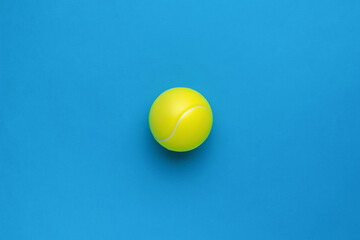 Minimal concept of a large tennis ball on a blue background. Flat lay.