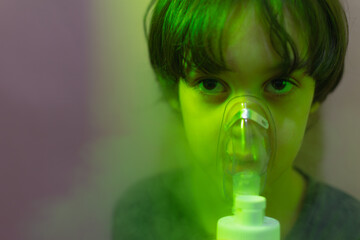 the child does inhalation, the boy inhales the medicine through the mask