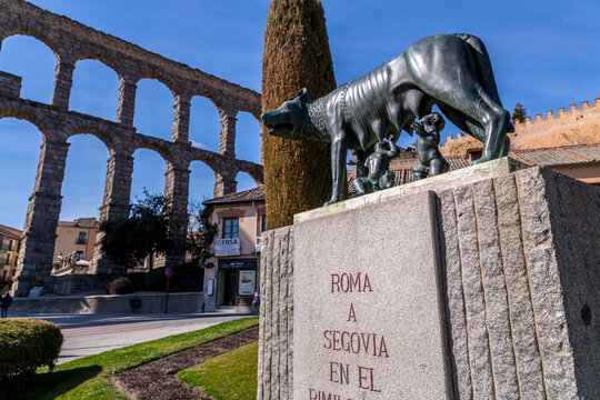 The Capitoline Wolf statue under the Roman aqueduct in Segovia
