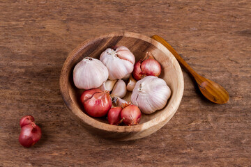 Onion and garlic in wooden bowl on old wood background. vintage