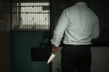 A criminal businessman wearing a white long-sleeved shirt holding a bloody knife is brutally...