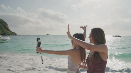 Asian young women having fun and enjoy vlogging from on the island. Summer vacation at sea for a happy female on the beach..Young adult woman who is carefree and freedom. blogger travel. slow motion