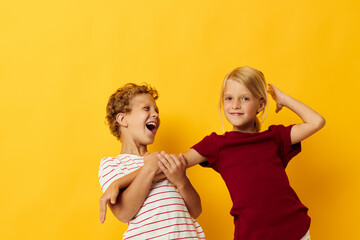 cheerful children cuddling fashion childhood entertainment yellow background