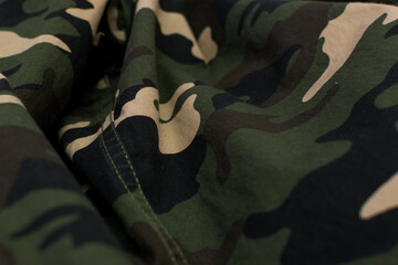 Military camouflage green, black, brown and beige uniform, background, close up