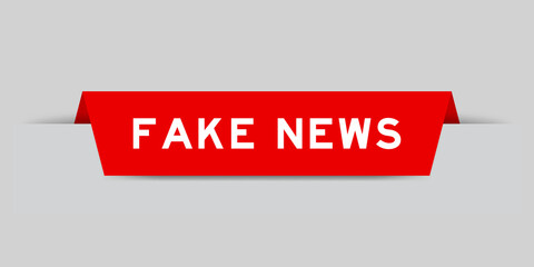 Red color inserted label with word fake news on gray background